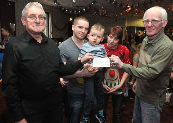 Clifford Heaton presents a cheque for £325 to Bobby Duckworth and his son Bailey (6) for a special 'Scoot' along with Dawn Hartley and Bob Duckworth at the Rosegrove Unity Working Mens Club.
