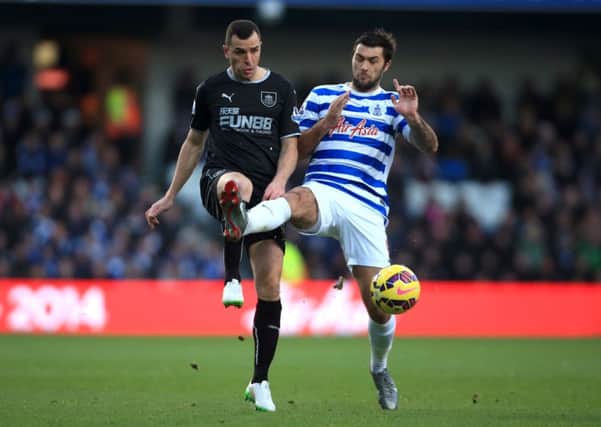 Dean Marney challenges former Clarets striker Charlie Austin in the 2-0 defeat at Loftus Road