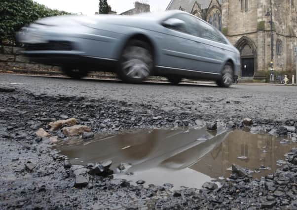 a car passing a pothole. Photo: Danny Lawson/PA Wire