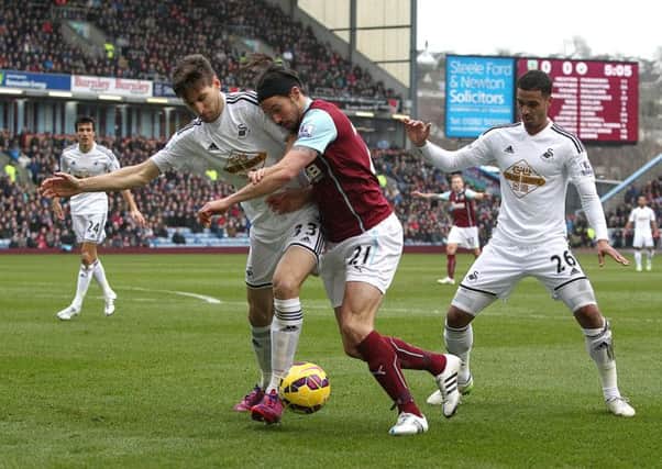 George Boyd attempts to force a route past Swansea City pair Federico Fernandez and Kyle Naughton (right)