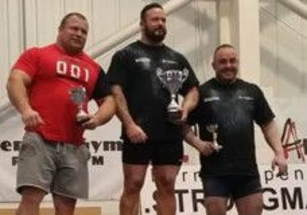 Colin Jones (centre) is victorious in the Burnley and Pendle Strongman competition
