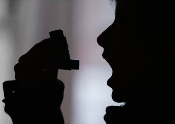 person using an inhaler. Photo: Yui Mok/PA Wire