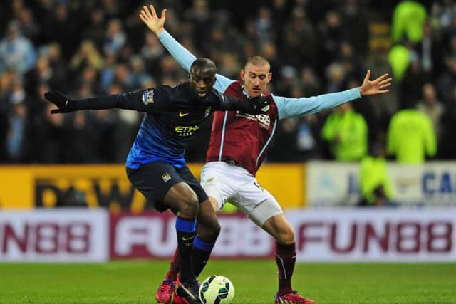 Manchester City's Yaya Toure tries to escape from David Jones