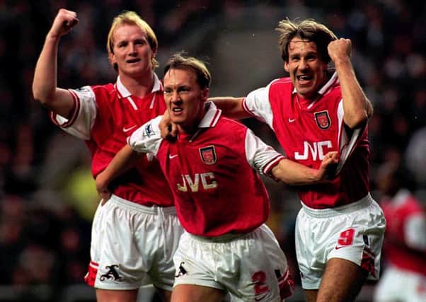 Arsenal's Lee Dixon celebrates from his diving header goal with team-mates Paul Merson (right) and Hartson against Newcastle today (Saturday). Pix Owen Humphreys/PA