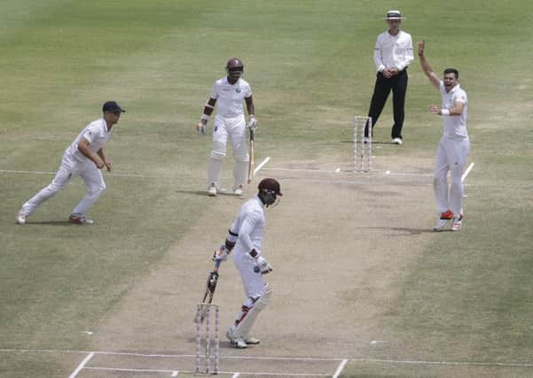 James Anderson, right, celebrates taking the wicket of West Indie's Marlon Samuels and levelling Ian Botham's record