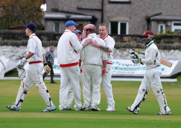 Earby bowler Jake Hargreaves, centre, is congratulated by team mates after taking the wicket of Read professional Keegan Petersen