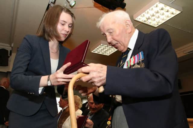 Lisa Vokorina from the Embassy of the Russian Federation presents Mr Robert Alwyn Taylor with his Ushakov medals.