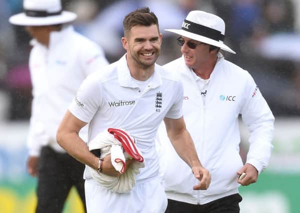 England's James Anderson smiles as he leaves the field after taking his 400th test wicket