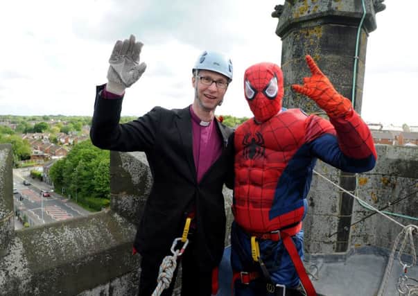 Bishop of Bunley the Rt Rev. Philip North prepare to abseil down the 90ft tower of St John's Church, Whittle Le Woods, with Spiderman. Photo Neil Cross