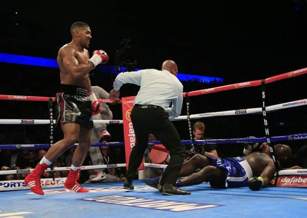Anthony Joshua (left) knocks down Kevin Johnson in their WBC International heavyweight title fight at the O2 Arena, London