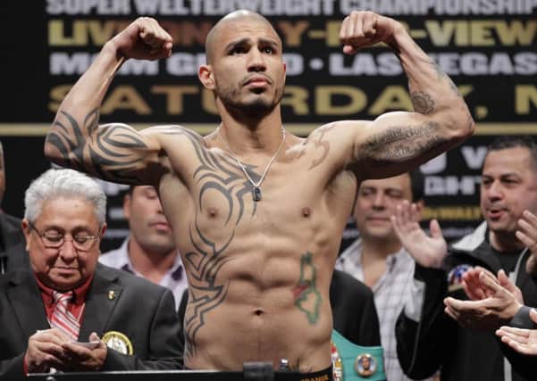 Miguel Cotto flexes during his weigh-in for Saturday's super welterweight title fight against Floyd Mayweather Jr., Friday, May 4, 2012, in Las Vegas. (AP Photo/Julie Jacobson)