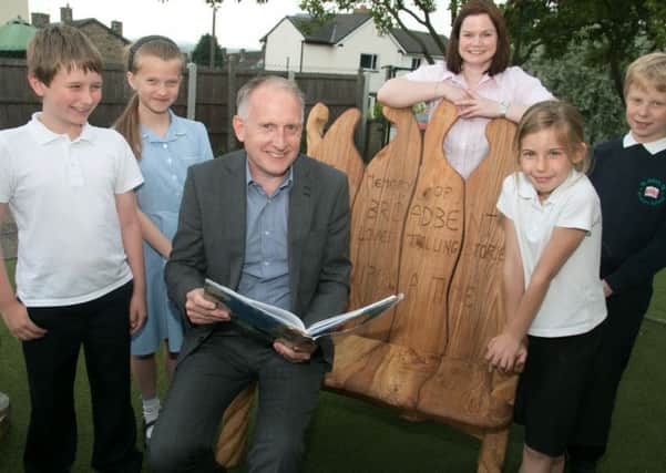 Read St John's C of E Primary School headteacher Mr David Smith reads to pupils from Mr Broadbent's memorial bench.