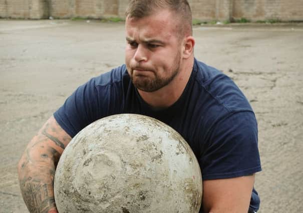 Strongman gets to grips with a 90kg concrete ball.
