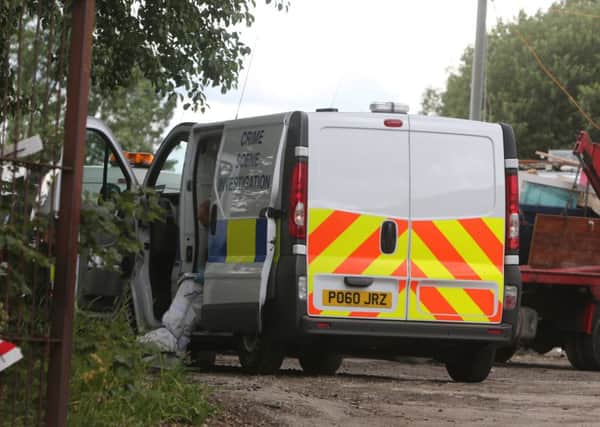 Police remain at the scene of the alleged murder at Pendle Skip Hire on Balderstone Lane.