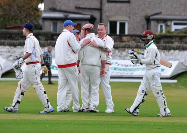 Read CC v Earby CC in the second round of the Ramsbottom Cup. Earby bowler Jake Hargreaves, centre, is congratulated by team mates after taking the wicket of Read pro Keegan Petersen. Picture by Paul Heyes, Saturday May 09, 2015.