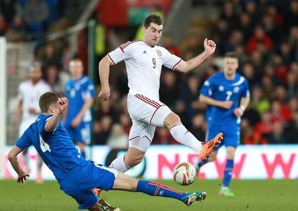 Wales' Sam Vokes (right) and Iceland's Kari Arnason battle for the ball during the international friendly at The Cardiff City Stadium, Cardiff. PRESS ASSOCIATION Photo. Picture date: Wednesday March 5, 2014. See PA story SOCCER Wales. Photo credit should read: David Davies/PA Wire