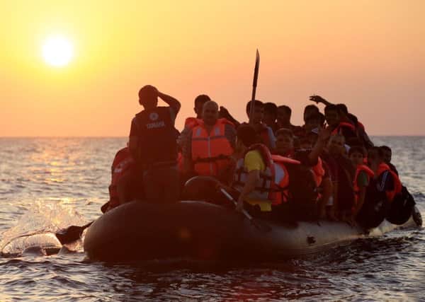 Migrants and refugees paddling a rubber dinghy close to the beach at Psalidi near Kos Town, Kos