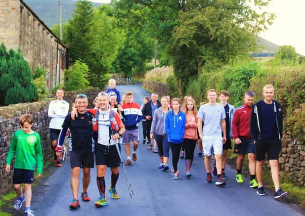 From The Abbey To The Hill Charity Run runners and their family going past Pendle Hill and approaching Barley.