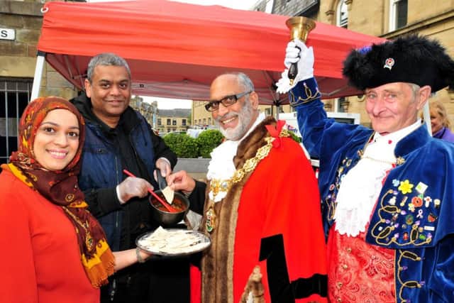 Hussain Osman of Kai's Sauces tempts the Mayor and Mayoress of Nelson, Uzman and Nawaz Ahmed to taste his sauce, announced by Town Crier Tony Edwards at Nelson Food Festival. Photo: David Hurst