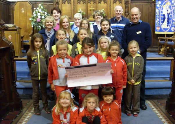 Hospice volunteer Brian Hough, church warden Jim Tabener and volunteers and members of the St Stephens Guides, Brownies and Rainbows