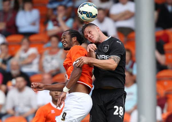 Blackpool's Nathan Delfouneso and Kevin Long battle for the ball in the air during the Pre-Season friendly at Bloomfield Road, Blackpool. PRESS ASSOCIATION Photo. Picture date: Saturday August 2, 2014. See PA story SOCCER Blackpool. Photo credit should read: Barry Coombs/PA Wire