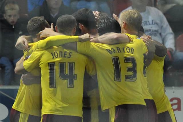 Players mob Burnley's Sam Vokes after he scores the winning goal
