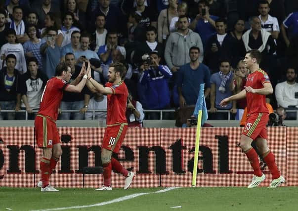 Sam Vokes congratulates Welsh goalscorer Gareth Bale with Aaron Ramsey