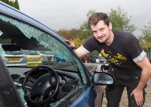 Danny McNicholas surveys the damage to a Ford Focus during the attack at Southfield Garage