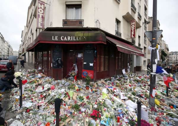 Floral tributes and candles left at Le Carillon, Paris, after terror attacks killed at least 129 people in the city. Photo: Steve Parsons/PA Wire