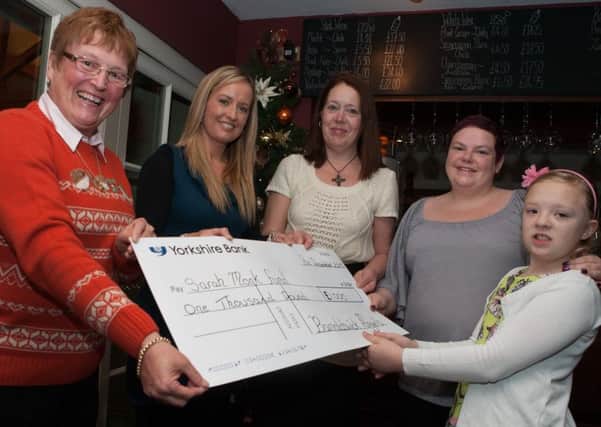 Jenny Purcell, Katie Collins and Mandy McLaughlin from the Barnoldswick Angels present Sarah Monk and her daughter with a cheque for £1,000 towards a final family holiday next year.