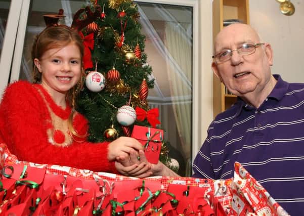 Jolie Forrest (7) presents Woodside resident Stan Tranter with his Christmas gift.