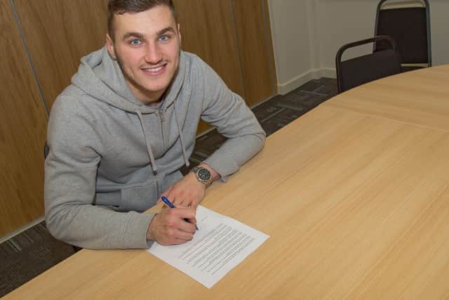 Conor Mitchell puts pen to paper