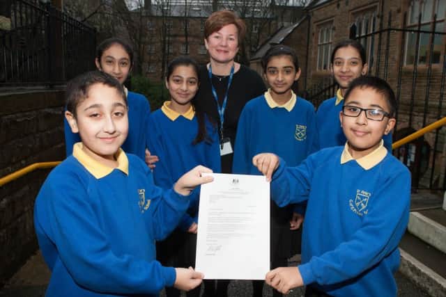 St Peter's C of E Primary School headteacher Mrs Catherine Greenwood with year 6 pupils and their letter from the education minister Nick Gibb congratulating the school on being in the top 100 Key Stage 1-2 performers.