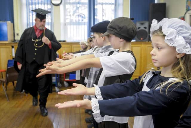 Christ Church Primary School in Colne is celebrating its 175th anniversary by dressing up in Victorian clothing.  Victorian headmaster John Meredith from the Heritage Learning Team inspects the pupils hands.