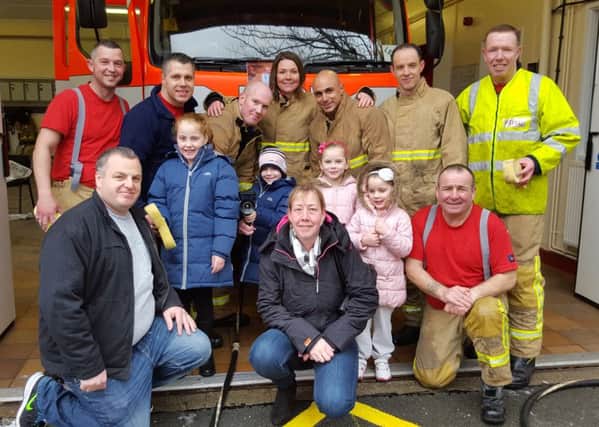 Tia Taggart and family with firefighters from Padiham Fire Station.