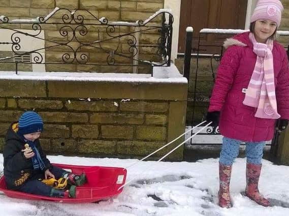 Scotty Crawford (3) and Ellie Crawford (10) having fun in the snow with their sledge