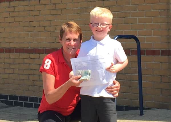 Blake, 4, with his teacher, Miss Wright and the money he raised