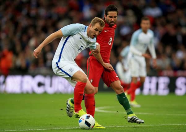 England's Harry Kane and Portugal's Joao Moutinho (right) battle for the ball during an International Friendly at Wembley