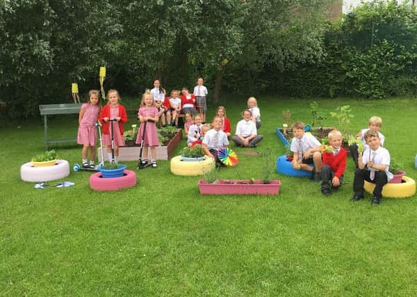 Pupils from Christ the King RC Primary School in Burnley enjoy their new garden that was created by staff as part of the Tesco Burnley Extra stores project (s)