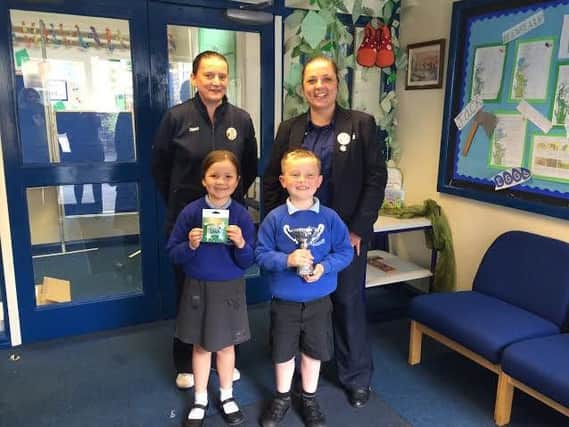 Delighted pupils from St James C of E Primary School receive a 20 voucher and trophy after winning the Tesco foodbank collection competition