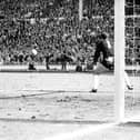 England's Geoff Hurst cracks a shot past German goalkeeper Hans Tilkowski to score the final goal of the World Cup Final against West Germany at Wembley