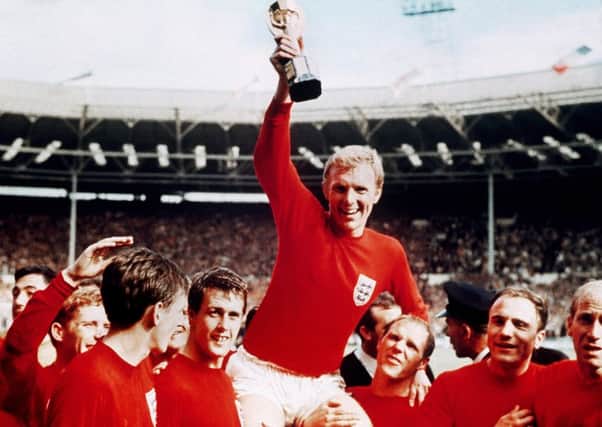 England's soccer captain Bobby Moore, carried shoulder high by his team mates, holds aloft the FIFA World Cup, July 30, 1966.