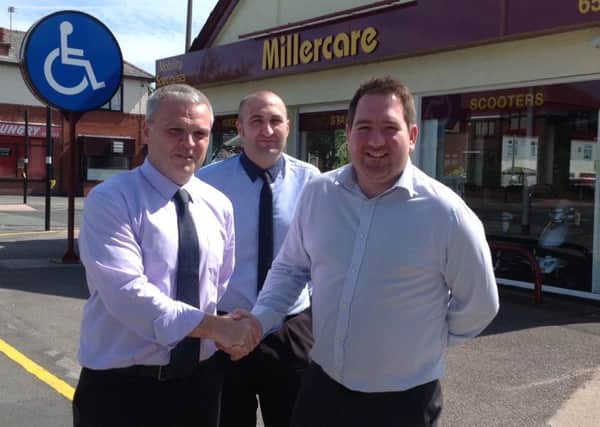 Eric Filbin, business development director at Millercare Mobility Specialists (left) shakes on the deal with Gavin Pennington sales manager at Alert Fire and Security, watched by Millercare HR manager Rob Coar ('s')