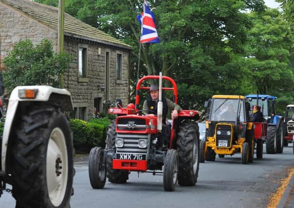 Members of the community gather to see the 8th annual charity Pendleside Tractor Run, with about 200 tractors driving through villages, starting from Sabden, raising funds for Cancer charities.