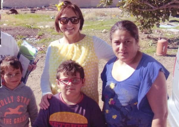 Colette Woskalo with a mother and her two children who she helped in Spain with the charity Swap Tears for Smiles (s)