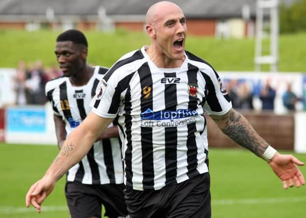 Striker James Dean celebrates scoring his second for the Magpies
