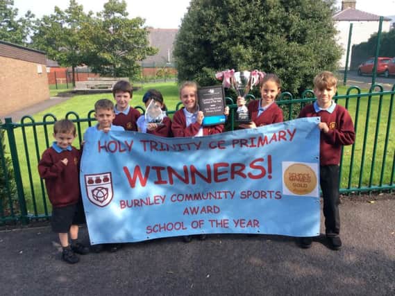 Pupils at Burnley's Holy Trinity C of E Primary School have plenty to smile about after scooping a hat-trick of sporting awards.