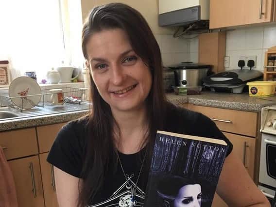 Helen Sutton with a copy of Fated, the first novel of The Faery Chronicles (s)