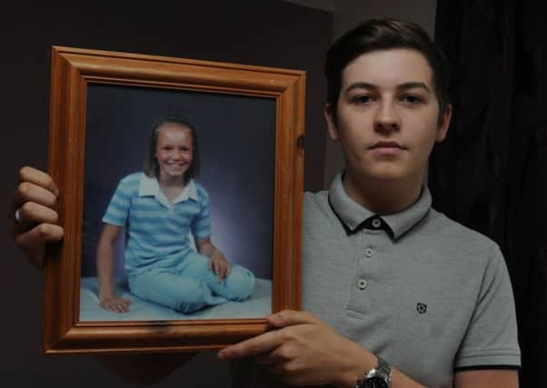Jack Goodison, 17, from Ashton-in-Makerfield, holds a photograph of his sister Rebecca