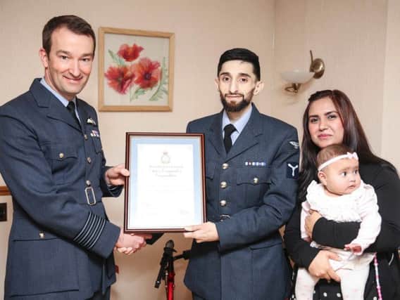 Shabz receiving his award from RAF Leeming Station Commander, David Arthurton, with his wife, Anum, and his younger daughter, Aisha.